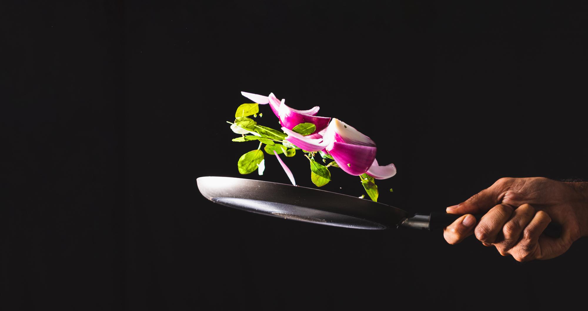 chef plating a modern dish with neon kitchen lights